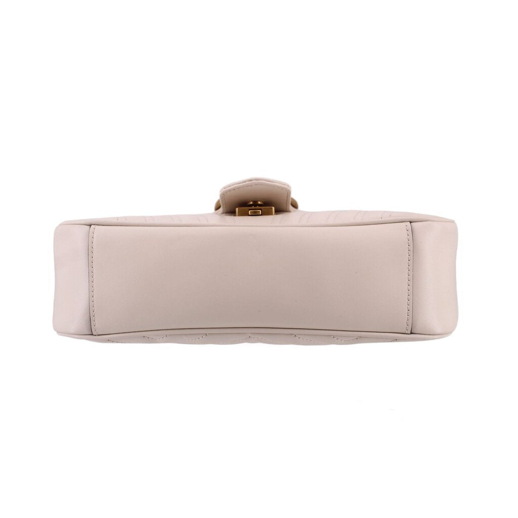 Cream medium shoulder bag bottom view with reinforced base stitching and top hardware