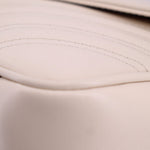 Cream leather close-up with visible stitching along curved seam