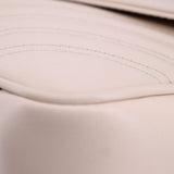Cream leather close-up with visible stitching along curved seam