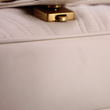 Cream flap shoulder bag with gold-tone clasp and quilted stitching
