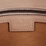 Cream bag zipper close-up with leather label and stitched edge