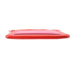 Red/pink wristlet pouch side view with textured leather and flat zipper edge