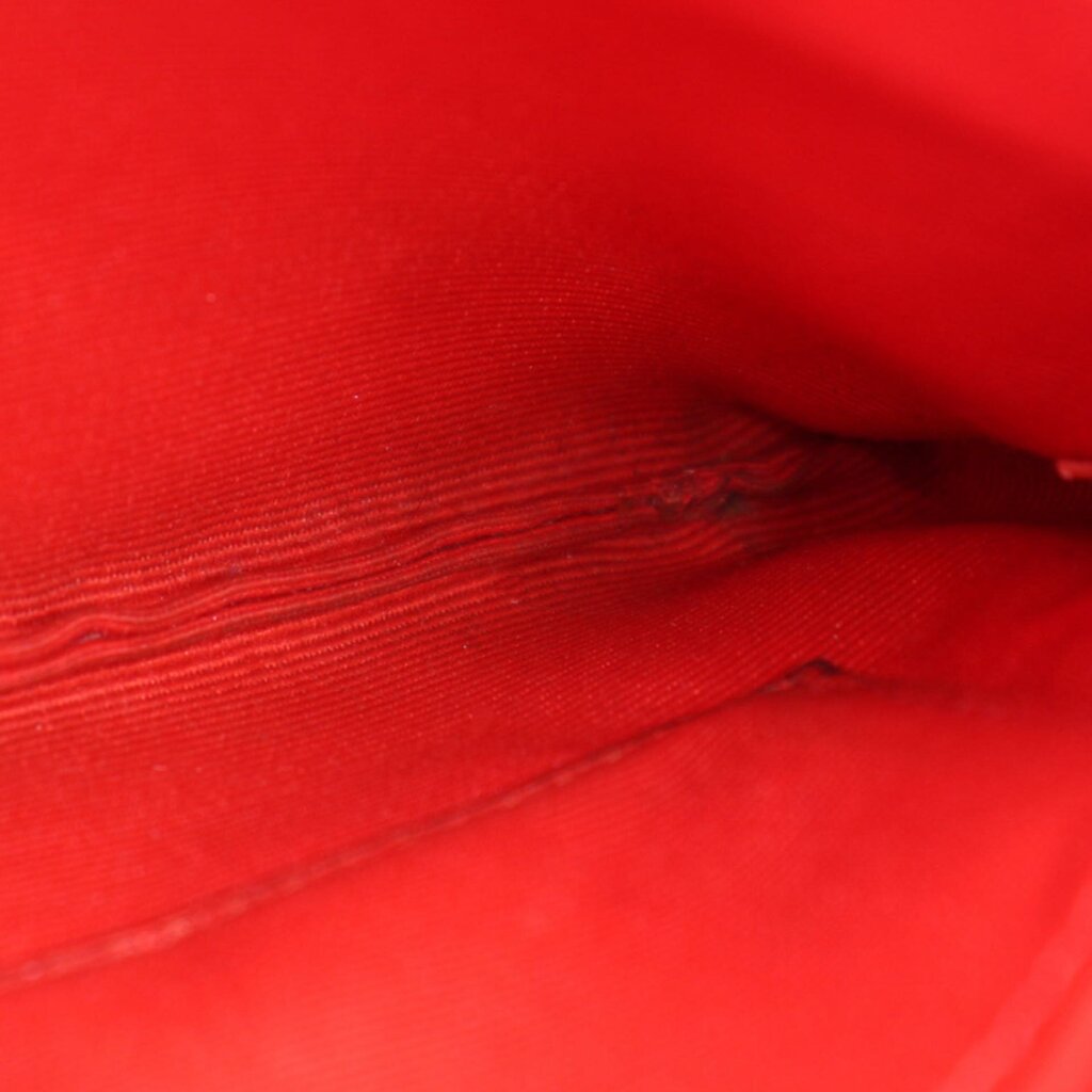 Textured leather close-up on red/pink wristlet pouch interior side panel