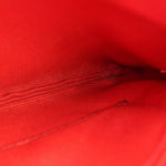 Textured leather close-up on red/pink wristlet pouch interior side panel
