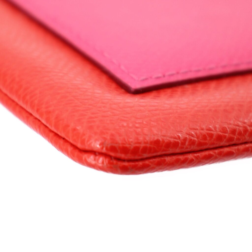 Close-up of red wristlet pouch corner and top flap with pink inner panel
