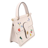Cream crossbody bag with side flap pocket, embroidered florals, and gold rings