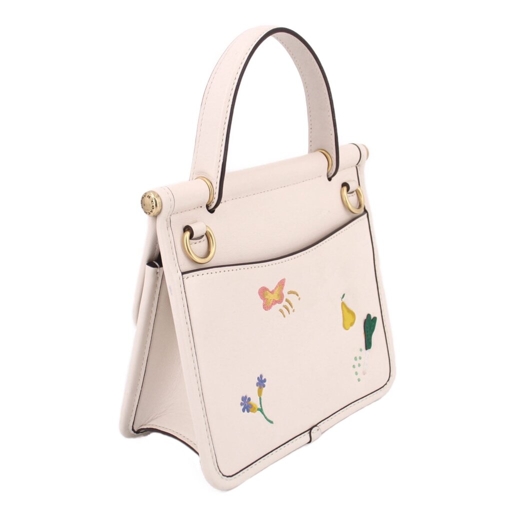 Cream top-handle bag side view with embroidered flowers and gold hardware