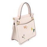 Cream top-handle bag side view with embroidered flowers and gold hardware