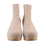 Beige suede ankle booties with stacked wooden heels and perforated midsole