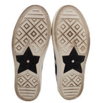 Outsoles of low-top sneakers with star graphic and patterned tread, dark and cream