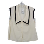 Cream sleeveless top with black-trimmed V-neck collar and button front