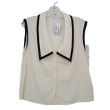 Cream sleeveless top with black-trimmed V-neck collar and button front