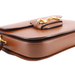 Brown leather shoulder bag close-up of top fold and Horsebit clasp.