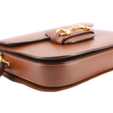 Brown leather shoulder bag close-up of top fold and Horsebit clasp.