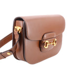Brown shoulder bag side view with gold Horsebit 1955 clasp and strap.