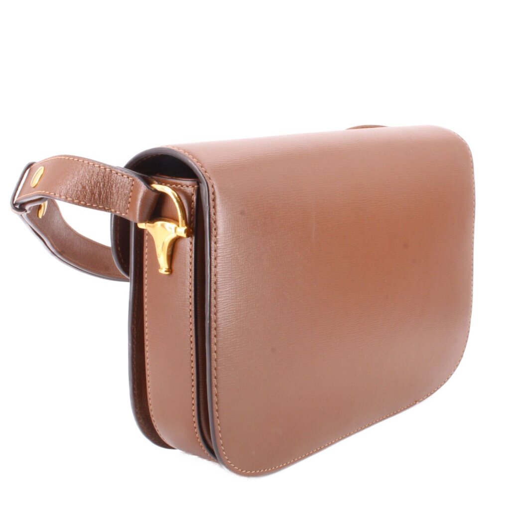 Brown leather shoulder bag side view with Horsebit hardware and strap loop.