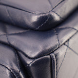 Dark navy leather close-up showing curved stitching and quilted panels
