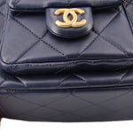 Navy quilted shoulder bag front with gold CC logo snap and top trim