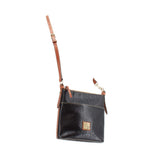 Black textured small crossbody bag with tan adjustable strap and front logo patch