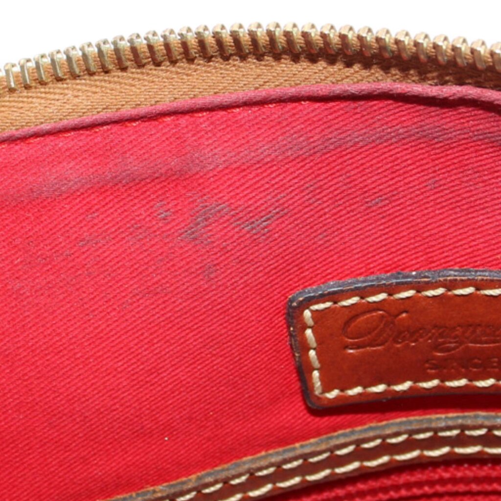 Red interior lining with gold-tone zipper teeth and stitched leather logo patch
