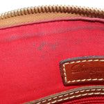 Red interior lining with gold-tone zipper teeth and stitched leather logo patch