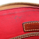 Red interior lining with gold-tone zipper teeth and stitched leather logo patch