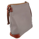 Taupe crossbody with side strap hardware, brown edge trim, and top zip