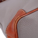 Taupe leather corner close-up with brown trim, rounded seam, and white stitching