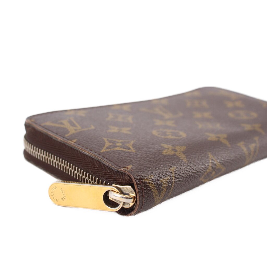 Zippy wallet end close-up with gold ring zipper hardware and Monogram pattern