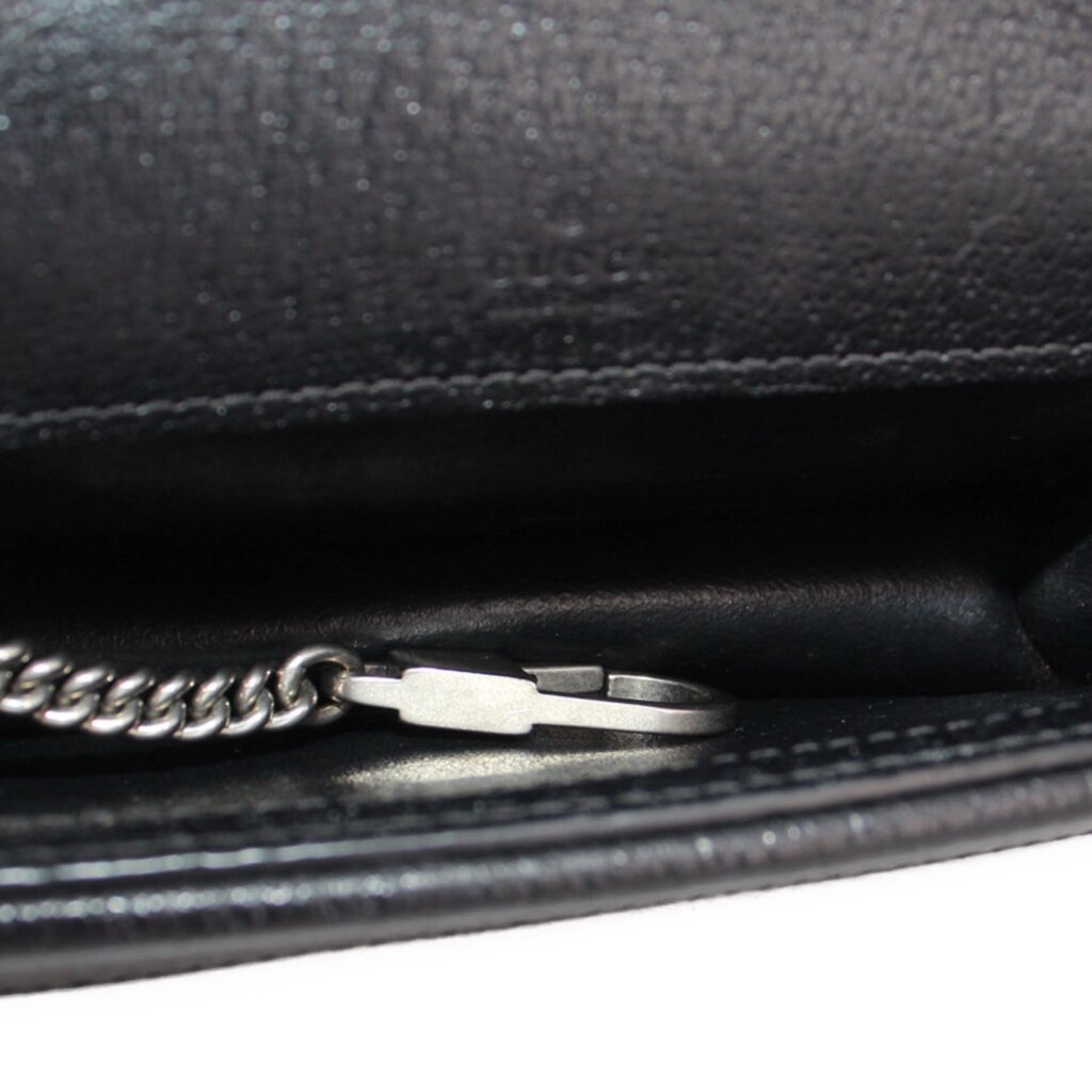 Close-up of silvertone hardware and stitched black leather lining on the mini bag