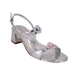 Metallic silver heeled sandals with ankle strap and pink buckle bow detail