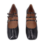 Black patent Mary Jane heels with two strap buckles across the foot and round toe