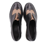 Black leather platform flats, open interior view with brogue wingtip stitching