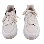 Pair of white women's court trainer sneakers with lace-up closure and textured sole