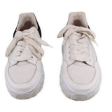 Pair of white women's court trainer sneakers with lace-up closure and textured sole