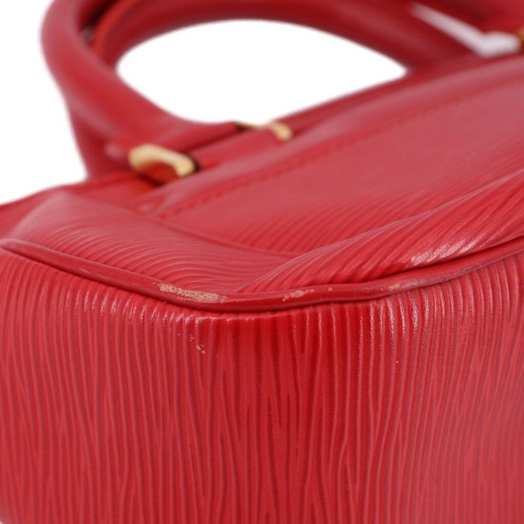 Close-up of red textured leather and top edge near strap attachment