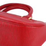 Close-up of red textured leather with gold-tone strap hardware