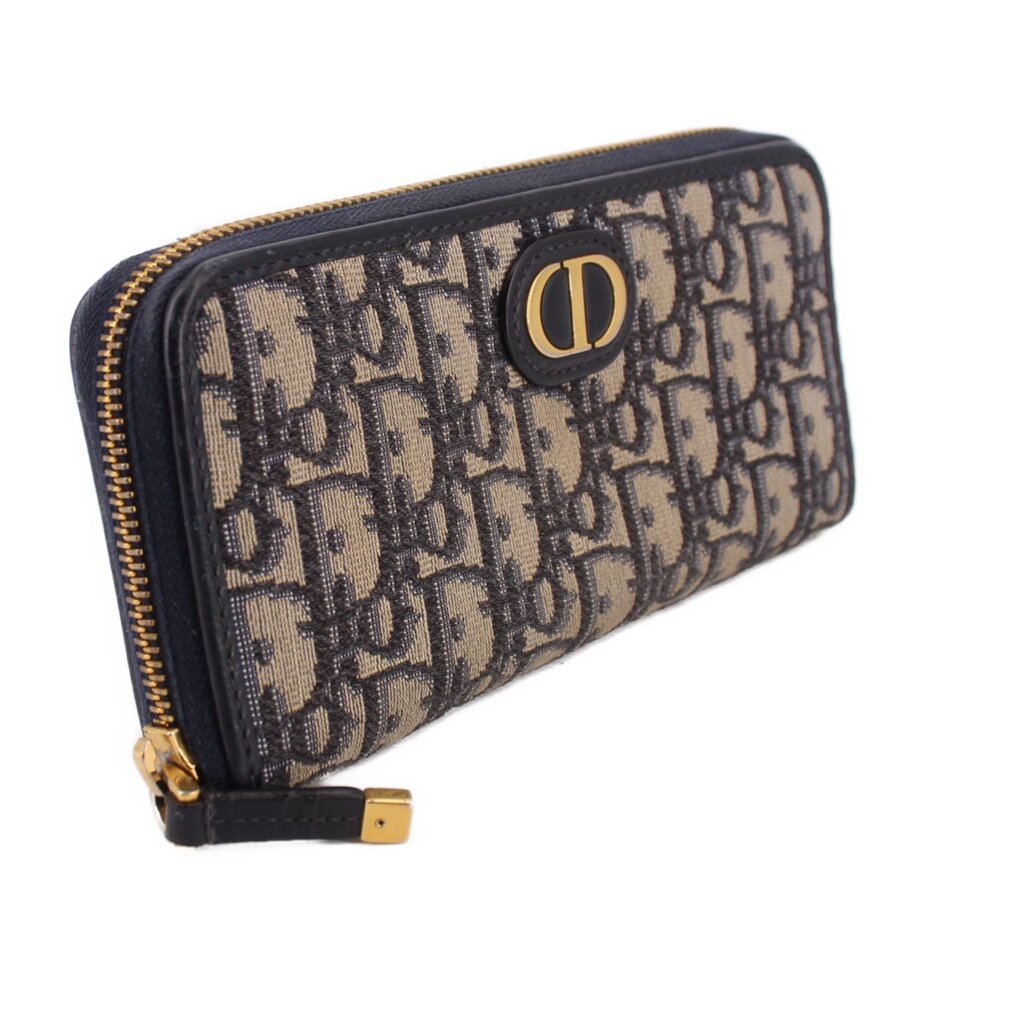 Long wallet in blue Dior monogram canvas with navy edges and gold-tone zipper hardware.