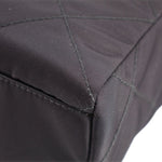 Black quilted tote bag corner with reinforced stitching and textured fabric edge