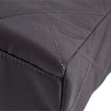 Black quilted tote bag corner with reinforced stitching and textured fabric edge