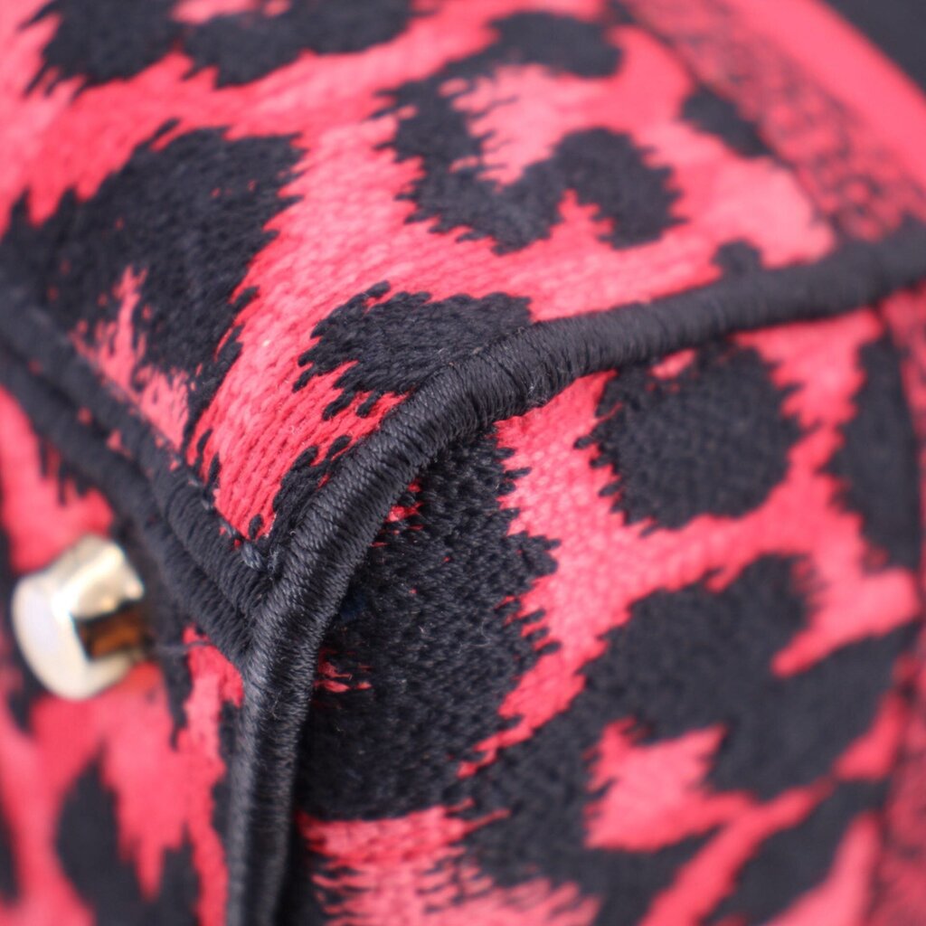 Close-up of leopard-print canvas mini tote corner with stitched black edging