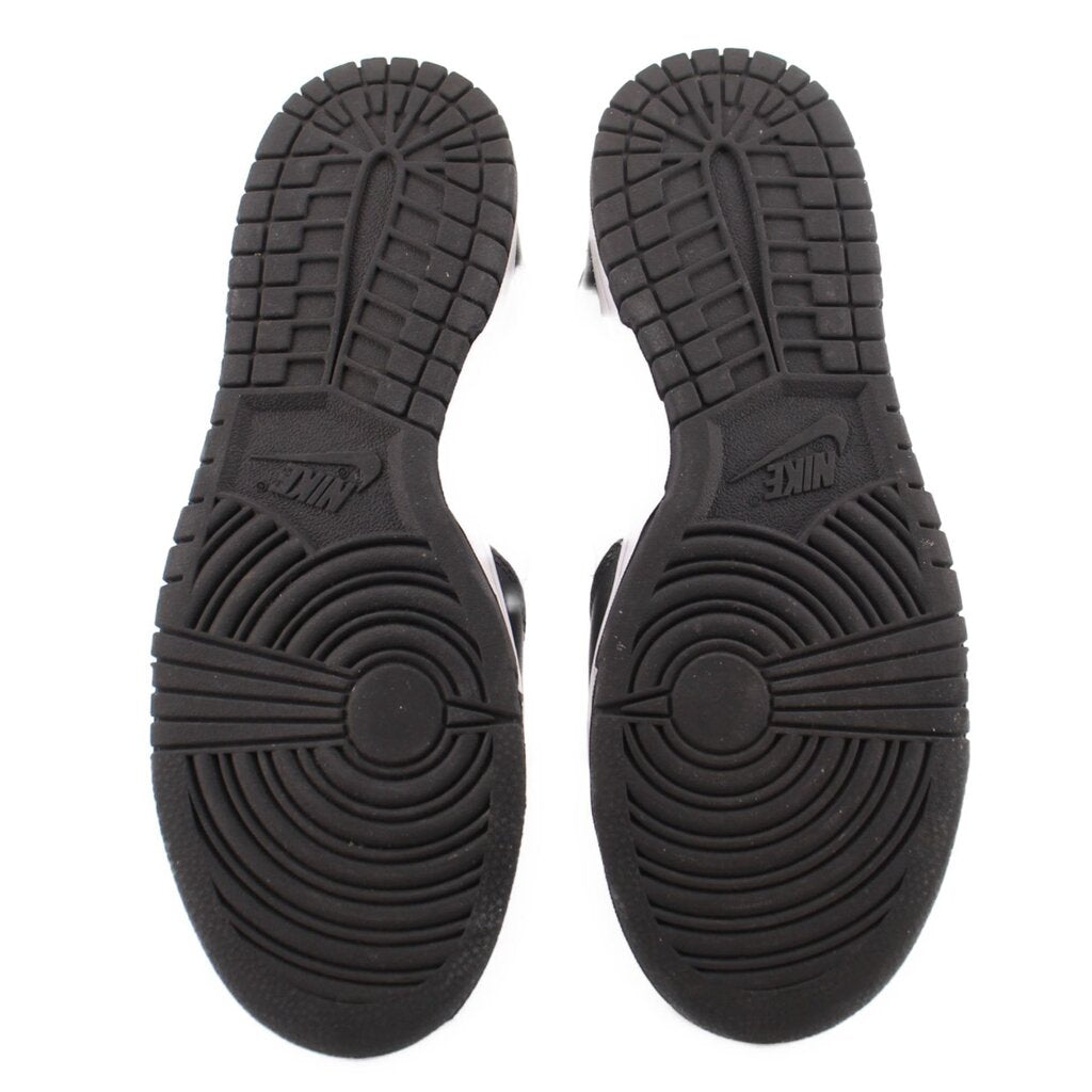 Black rubber outsole with textured tread and circular traction pattern
