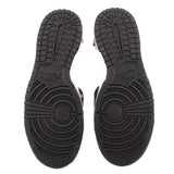 Black rubber outsole with textured tread and circular traction pattern