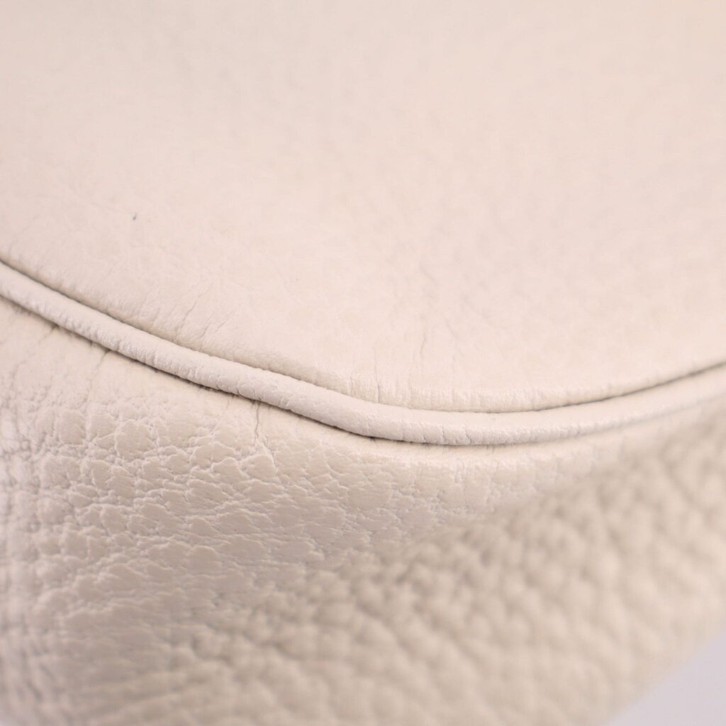 Cream pebbled leather close-up of rounded corner and stitched edge