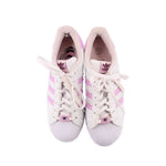 Pair of white lace-up sneakers with pink accents showing tongues and inner lining