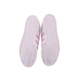 Outsole view of white sneakers with zigzag tread and pink stripe detailing