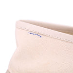 Cream canvas upper with visible side seam stitching and small blue mark