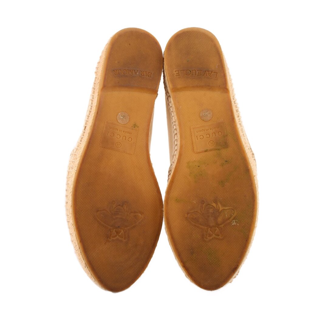 Tan interior footbed and outsole base of cream canvas flats, stamped lettering