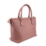 Blush leather satchel with top handles and crossbody strap, angled side view