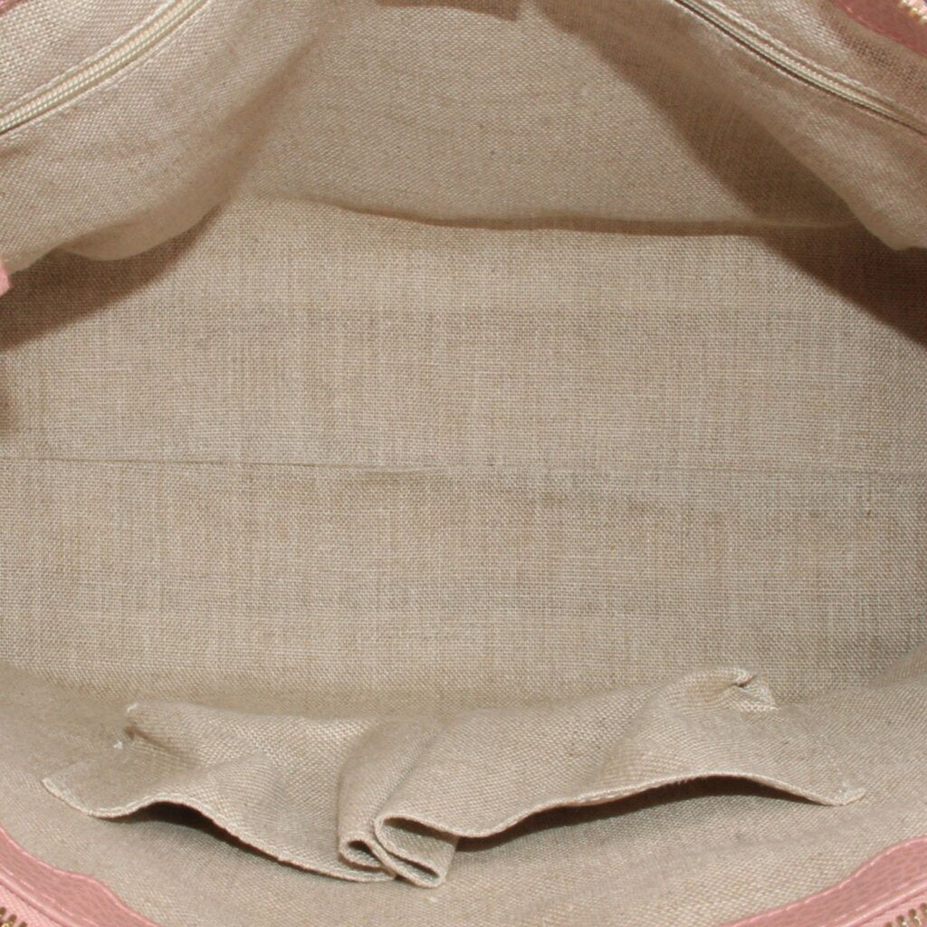 Interior lining view of blush satchel showing fabric lining and stitched edge